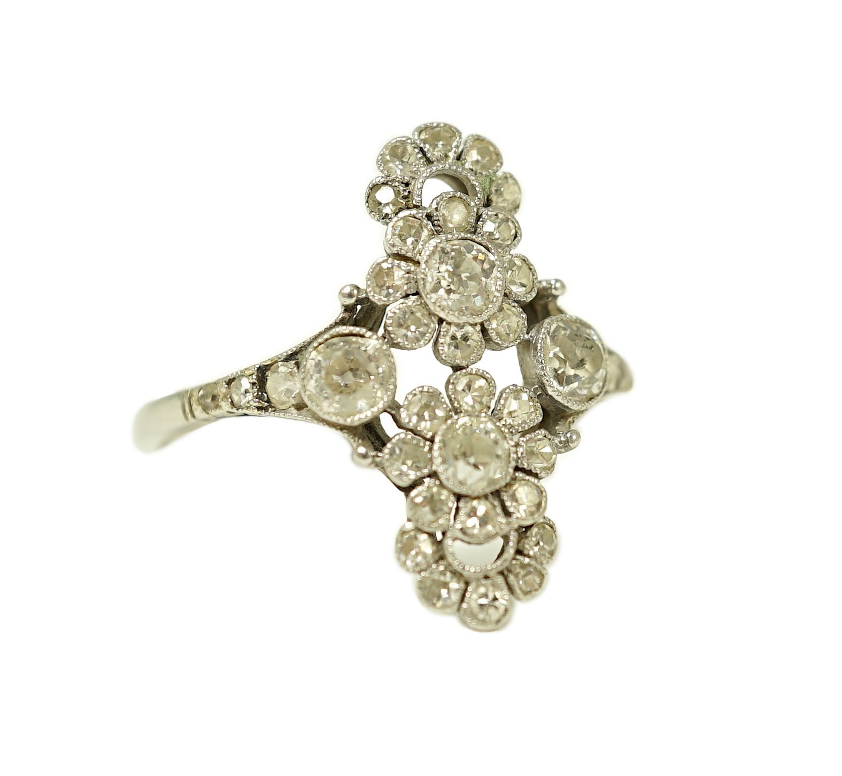 A 1920's platinum and millegrain diamond set flower head cluster upfinger ring